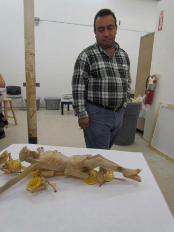 Manuel contemplates his carving of the crucified Christ